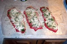 four fish fillets on a counter with parmesan cheese