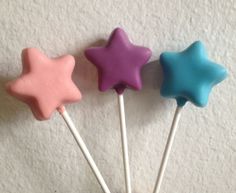 three star shaped lollipops sitting on top of each other in front of a white wall