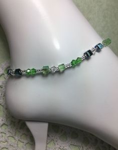 "An All Crystal Anklet Full Of Spiritual Healing. If You Love Green And Crystal This May Be For You. Made With 4mm. Clear, Light Green, Dark Green Bicone, White Wavy Rondelle Swarovski Crystals, 6mm. Faceted Square Light Green, Metallic And Dark Green Glass Crystals. CRYSTAL also known as Clear Quartz, is the \"Stone that brings the Energy of the Stars to the Soul.\" It aligns human energies - thoughts, emotions and consciousness - to the energies of the Universe bringing connection and communic Elegant Green Anklet For Gifts, Elegant Green Anklets For Gift, Adjustable Crystal Anklets As Gift, Diy Anklets, Crystal Suncatchers Swarovski, Healing Crystal Bracelets, Pearl Ankle Bracelet, Beautiful Anklet, Crystal Anklet