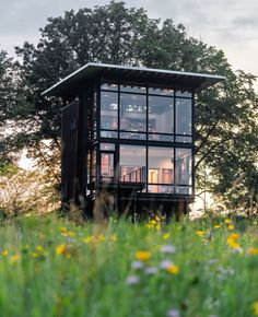 a small house sitting on top of a lush green field