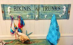 there are two signs on the wall that say bikinis & trunks and seahorses