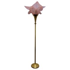 a tall pink flower on a brass stand