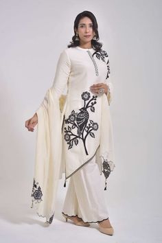 White three fourth sleeves cross cut kurta with contrasting black bird gardenia applique thread embroidery and tassel, cowrie shells embellishments on the corners. Paired with a schiffli embroidered scallop border palazzo and bloom embroidered cutwork border dupatta. - Aza Fashions White Long Sleeve Palazzo Set With Floral Embroidery, White Floral Embroidered Long Sleeve Palazzo Set, Elegant Off White Sets With Printed Motifs, Elegant Long Sleeve Sets With Motifs, Elegant Cotton Palazzo Set With Printed Motifs, Elegant Cream Cotton Palazzo Set, Elegant Cotton Palazzo Set With Cutdana, White Palazzo Set With Printed Motifs, Elegant White Sets With Motifs