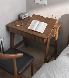 a wooden desk with an open book on it and a chair in front of it