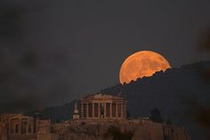 the full moon is seen over part of the city