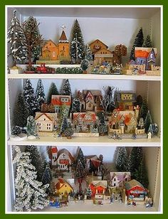 a shelf filled with lots of different types of christmas trees and houses on top of it