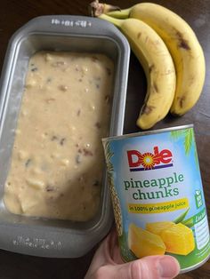 a can of pineapple chunks next to two bananas and a tin of dip on a table