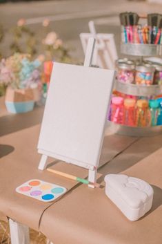 an easel and paintbrush sitting on top of a table