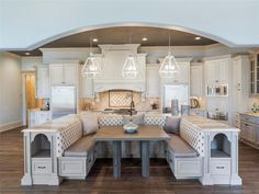 a large kitchen with white cabinets and an island in front of the stove top oven