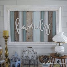 a family sign hanging on the wall above a table with candles and other items in front of it