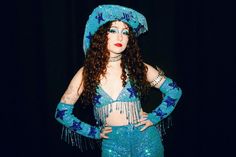 a woman with long hair wearing a blue costume