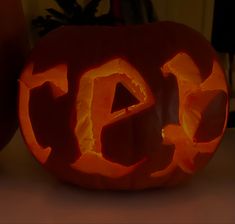 an orange carved pumpkin with the word eat carved into it