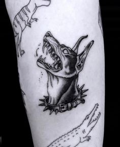 a black and white photo of a tattoo with an alligator on it's leg