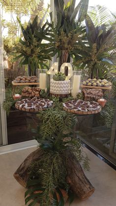 the dessert table is decorated with greenery and cookies