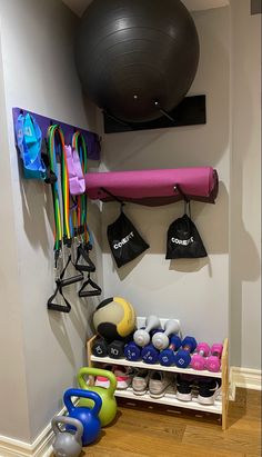 there is a gym room with various exercise equipment on the wall and in the corner