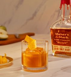 a glass filled with liquid next to an apple