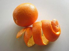 two oranges cut in half on a white surface