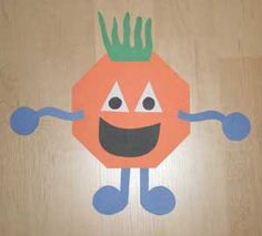 an orange with a green crown on it's head and arms, standing in front of a wooden floor