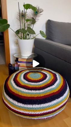 a living room with a couch, coffee table and potted plant on the floor