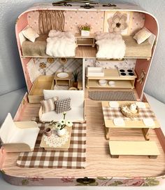 a doll house with furniture and accessories in the inside of an open suitcase that is on top of a table