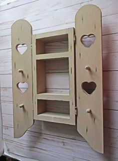 a wooden cabinet with hearts cut out of it's sides and two shelves on each side