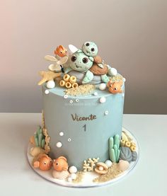 a blue cake decorated with sea animals and seashells