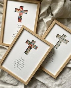 three framed cross pictures sitting on top of a bed