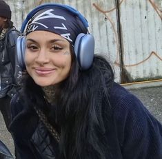 a woman with headphones on smiling for the camera