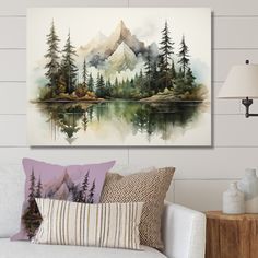 a living room with a white couch and painting on the wall above it that has a mountain lake surrounded by pine trees