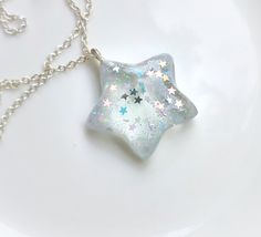 How cute is this puffy star charm on a silver plated chain necklace?!? Handmade with crystal clear non yellowing UV Resin and holographic star sequins and glitter.  Pendant is approximately 1 inch in heighth and width. Comes with a 16 inch silver plated stainless steel chain.  Need a special color or a personalized pendant? Just send us a message with the color or set you want ♥️ All jewelry is handmade by Stella and Herman Co and may have slight variances in each piece. Colors may be different