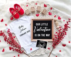 a baby announcement is displayed on top of a lace doily with red flowers and hearts