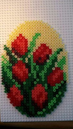 a close up of a lego artwork with red flowers in the center and green stems