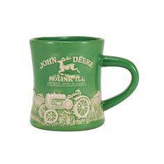 a green coffee mug with an image of a horse and carriage painted on it's side