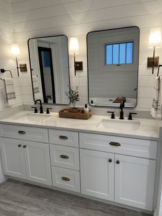 a bathroom with double sinks and mirrors in it