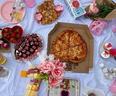 a pizza sitting on top of a table covered in food