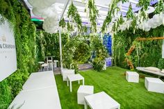 a room filled with lots of white furniture and greenery