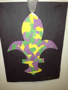 a paper cut out of a fleur de lis with yellow and purple colors