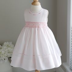 This Sweet Little Smocked Dress Is By Feltman Brothers Fine Children's Apparel. The Pale Pink Hue Looks Like Cotton Candy! The Sleeveless Style Will Keep Your Baby Girl Cool During Summer Months. The Detail In This Dress Is Super Appealing. The Rounded Neckline And The Arm Openings Have A Matching Pink Trim That Has Been Hand Faggoted (A Very High-End Stitching Detail) The Bodice Meets The Waist With A Petite Piping And Follows With Gorgeous Smocking Done In A Contrasting Pink Shade Of Embroider Sleeveless Smocked Dress For Summer Playtime, Summer Baptism Smocked Dress, Pink Smocked Bodice Dress For Dress-up, Spring Sleeveless Smocked Dress For Playtime, Sleeveless Smocked Dress For Spring Playtime, Sleeveless Smocked Dress For Playtime, Sleeveless Smocked Dress With Smocked Back For Playtime, Sleeveless Smocked Bodice Cute Dress, Pink Dress With Smocked Bodice For Dress-up