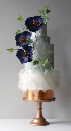 a three tiered cake with blue flowers on top