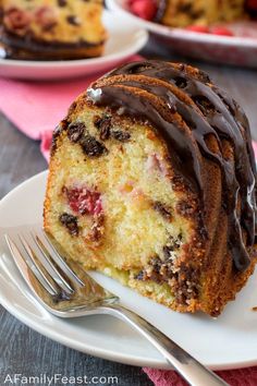 a bundt cake with chocolate drizzled on top and strawberries in the background