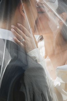 a man and woman kissing under a veil