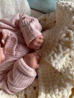 a baby laying on top of a white blanket