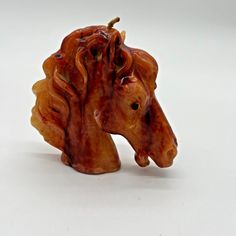 a ceramic horse head on a white background