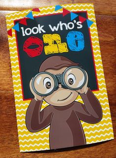 a card with an image of a monkey looking through binoculars and the words look who's on it