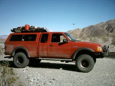 a red pick up truck parked in the desert