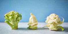 three pieces of broccoli sitting next to each other on top of a table