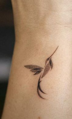 a small bird tattoo on the side of a woman's lower back ribcage