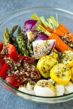 a glass bowl filled with different types of veggies and seasoning on top of it