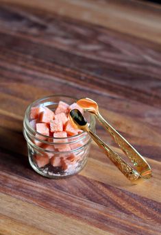 a jar filled with diced watermelon sitting on top of a wooden table