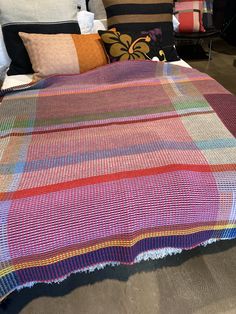 a multicolored blanket on a bed in a room